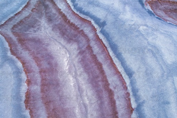 Aerial view of vibrant multicolored sandstone formations offering a stunning display of natural colors. The intertwining patterns and vivid contrasts create a captivating mosaic like appearance