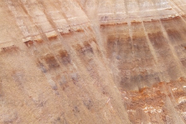 Aerial view of a multicolored sandstone exhibiting unique textures and earthy hues. The striations and patterns form an intriguing abstract landscape, highlighting the beauty of mineral formations