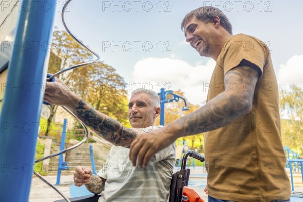 Two friends, one in a wheelchair by cerebral palsy, enjoy a sunny day at an inclusive park, interacting with accessible play equipment Both have tattoos and are showcasing friendship and accessibility