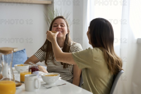 A lesbian couple enjoys a joyful breakfast together, sharing smiles and affection This heartwarming moment captures the essence of love and connection in everyday life
