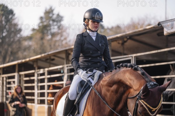 A focused female teenager competes in a classical dressage event, dressed in traditional attire, riding a well-groomed horse