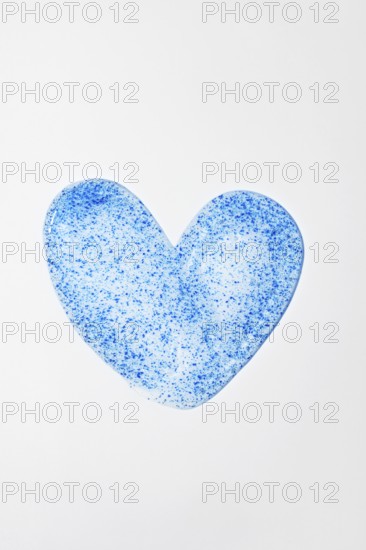 A close-up of face scrub in a heart shape, featuring blue micro-exfoliating particles Ideal for promoting skincare routines, beauty treatments, and product aesthetics
