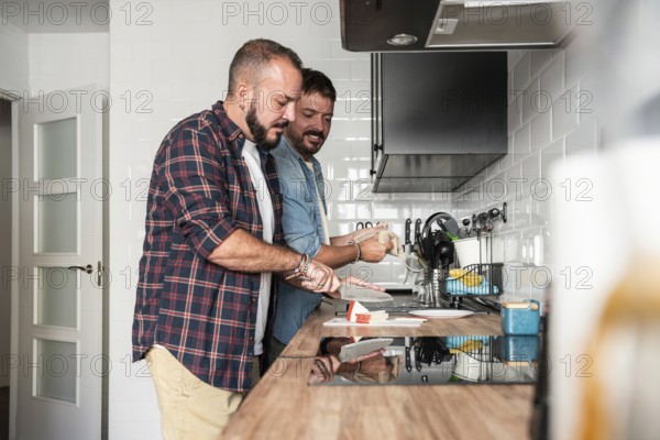 A joyful gay couple prepares a meal together in their modern kitchen, showcasing a harmonious relationship and a love for shared cooking experiences