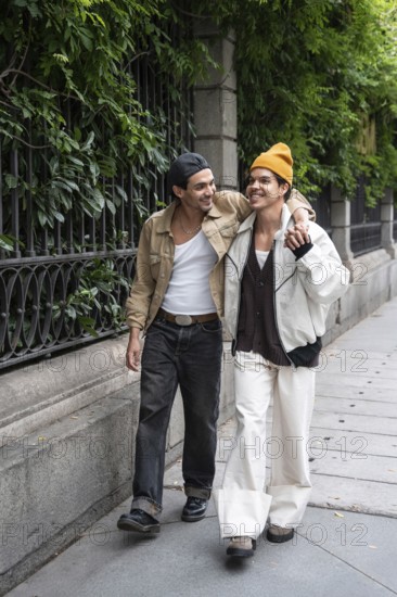 A joyful gay couple strolls arm in arm along a leafy city sidewalk, sharing smiles and enjoying each other's company on a bright day, depicting a loving relationship