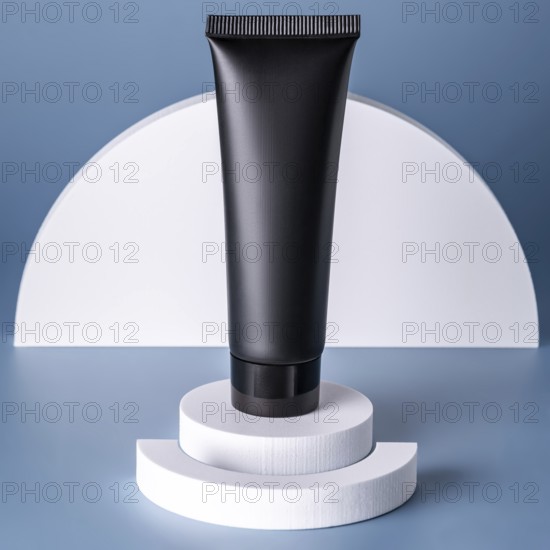 A sleek black cosmetic tube stands atop layered white circular podiums against a soft blue backdrop, emphasizing modern beauty packaging design