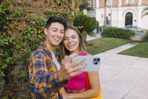 A joyful lesbian couple takes a selfie while enjoying a sunny day in a park. Their smiles reflect love, pride, and the joy of being together in an inclusive world