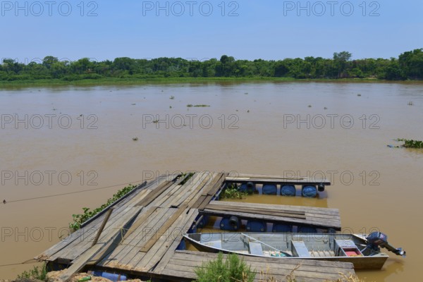 A wooden jetty on the riverbank with a boat tied just below the water surface, Porto Jofre, Pantanal, Mato Grosso, Brazil