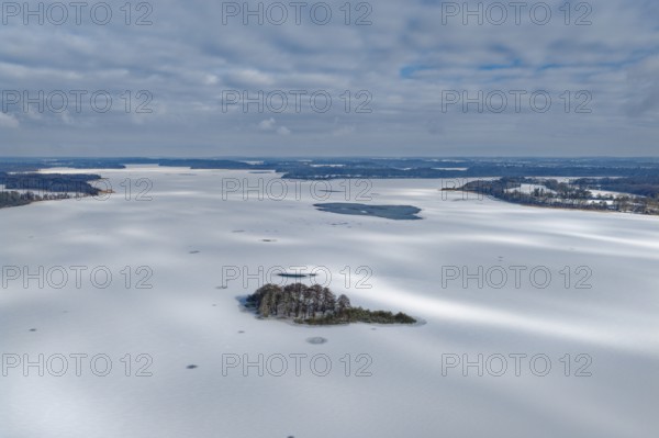 There is snow on the frozen Schaalsee near Zarrentin in the UNESCO Schaalsee Biosphere Reserve. In front is the island of Möwenburg. aerial view. Zarrrentin, Mecklenburg-Western Pomerania, Germany