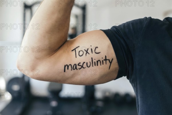 Muscular man flexing bicep with text toxic masculinity highlighting harmful male stereotypes. Generative AI, AI generated