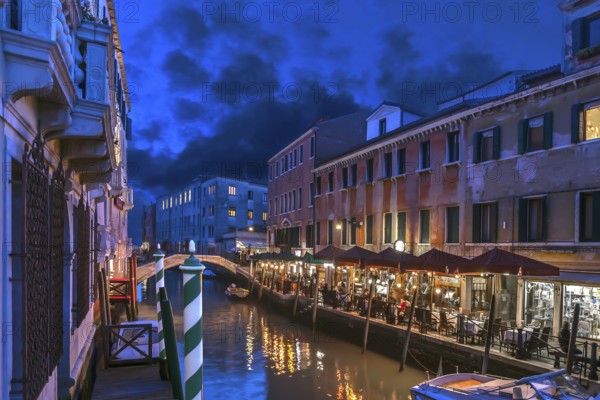 In the evening, illuminated restaurant on the canal, Venice, Veneto. italy