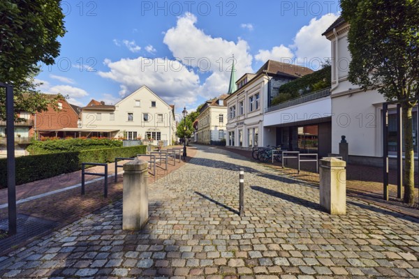 Pedestrian zone, barrier bollard, general development, houses, residential buildings and commercial buildings, street made of paving stones, trees, blue sky, cumulus clouds, Mühlenstraße, Lüdinghausen, Münsterland, Coesfeld district, North Rhine-Westphalia, Germany