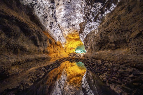Lava tunnel, illuminated lava cave with perfect reflection in an underground lake, Cueva de los Verdes, Lanzarote, Canary Islands, Spain
