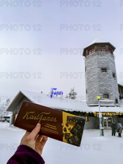 Karl Fazer hand holding chocolate in front of a Fazer shop, typical Finnish chocolate, Ranua, Lapland, Finland
