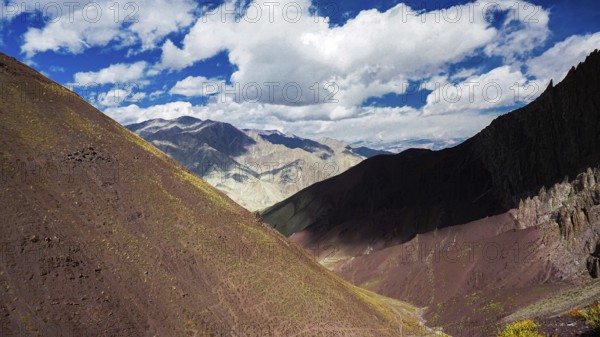 View of a shady, colorful mountain landscape with dramatic sky and clouds, trekking in Ladakh, Stok la, Himalayas, India