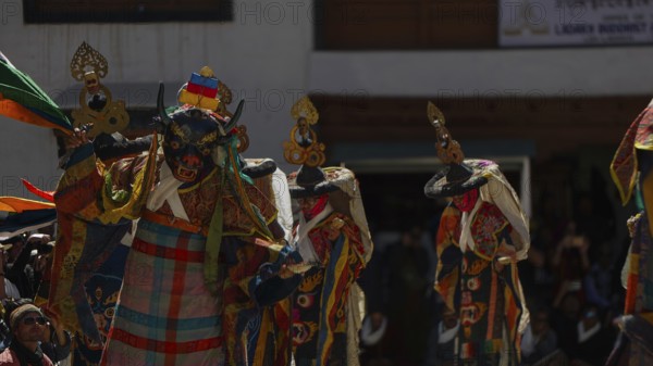 Colourful masked dancers perform a traditional performance in front of an audience, traditional cultural festival in Leh, trekking in Ladakh, Himalayas, India