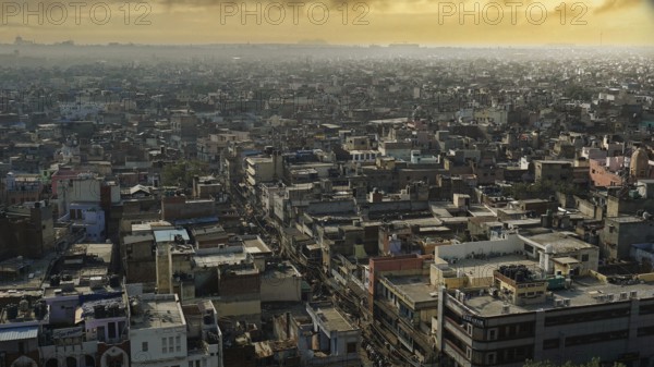 View of the rooftops of an expansive cityscape at sunset, Delhi, India