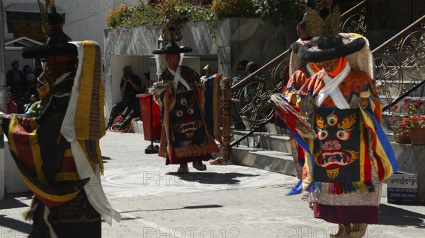People in traditional costumes dance outside at a cultural event in Leh, trekking in Ladakh, Himalayas, India