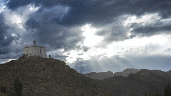 Small monastery on a mountain under dramatic cloudy sky, Leh, trekking in Ladakh, Stok la, Himalayas, India