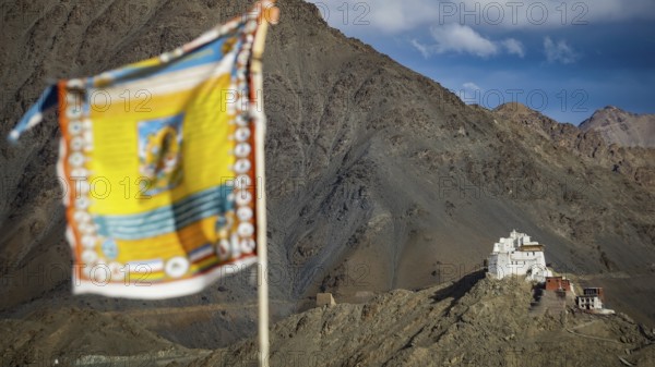 View of Namgyal Tsemo Buddhist mountain temple, with colorful prayer flags against a blue sky, trekking in Ladakh, Stok la, Himalayas, India