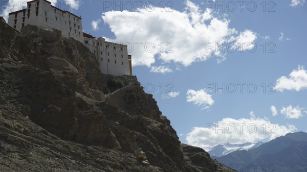The Leh Palace is majestically perched high up on a rocky mountain with clouds in the bright blue sky Leh, trekking in Ladakh, Himalayas, India