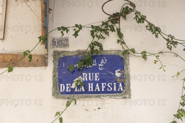 A Tunisian street sign for Rue de la Hafsia written in French and Arabic in the main thoroughfare in Tunis Medina, a world heritage site in Tunisia, North Africa