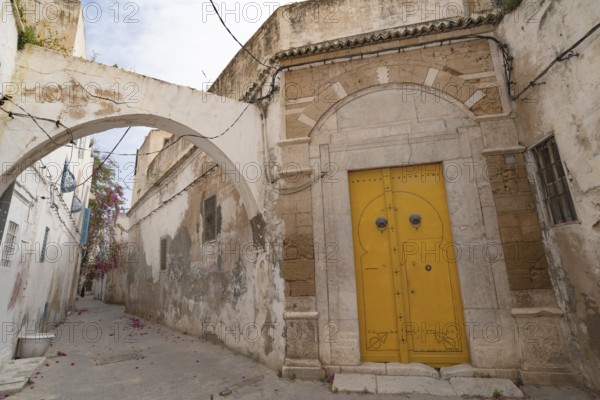 An ornate yellow door of typical Tunisian architecture in the colourful alleyways of the Medina in Tunis, capital of Tunisia, North Africa