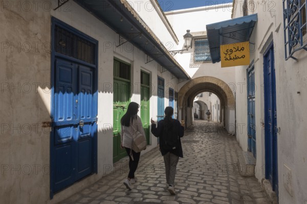 Tunis, Tunisia 4th May, 2024 Two young Tunisian women walk in the traditionally decorated narrow streets of Tunis Medina, Tunisia, North Africa