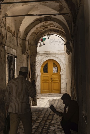 Tunis, Tunisia. 13th May 2024 A dark narrow alley with a bright yellow door, a traditional scene in the daily life of Tunisians living in the Kasbah of Tunis, Tunisia, North Africa