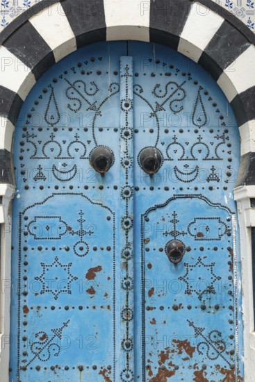 Detailed design of a traditional blue door in the Tunisian cliff top village of Sidi Bou Said, overlooking historical Carthage and the Gulf of Tunis. Tunisia