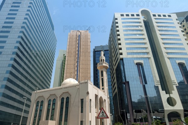 Abu Dhabi, United Arab Emirates. June 23rd 2019 A mosque among modern glass fronted office buildings, typical architecture in the city of Abu Dhabi, United Arab Emirates, Middle East