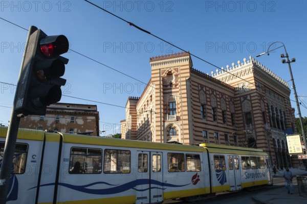 Sarajevo, Bosnia and Herzegovina. July 24th 2019 A tram passing Sarajevo City Hall, known as Vijecnica in the old town of the Bosnian capital, Bosnia and Herzegovina