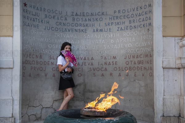 Sarajevo, Bosnia and Herzegovina. July 24th 2019. A young girl poses in front of The Eternal flame is a memorial to the military and civilian victims of the Second World War in Sarajevo, Bosnia and Herzegovina