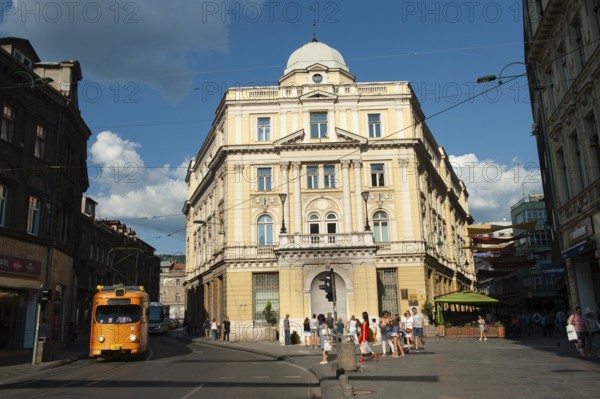 A tram passing in the street beside The Eternal flame, a memorial to the military and civilian victims of the Second World War in Sarajevo, Bosnia and Herzegovina