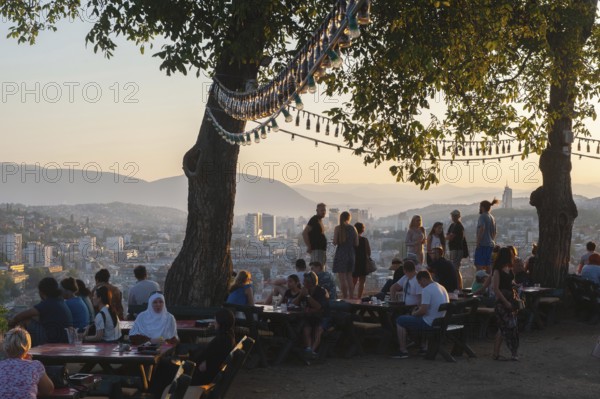 Sarajevo, Bosnia. July 25th 2019 Tourists watch the sunset from the terrace of the Park Princeva Restaurant on the hill above Sarajevo, Bosnia and Herzegovina