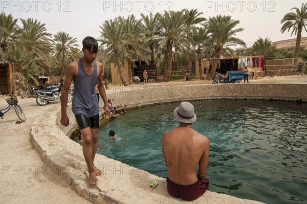 Siwa Oasis, Egypt. April 12th 2018. Young Egyptian men hang out and swim at Cleopatras Pool, Siwa Oasis, Egypt