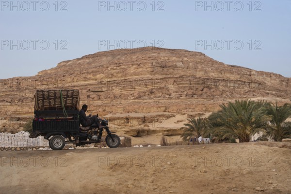 Siwa, Egypt. March 11th 2018 A tuc tuc driver checks his phone while parked in the desert of Siwa Oases in Egypt, North Africa