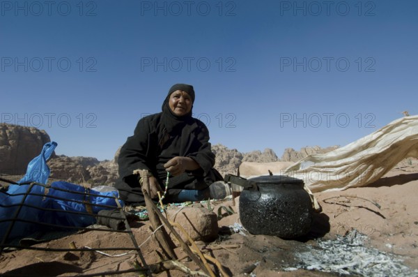 Petra, Jordan. December 13th 2012 Jordanian Bedouin woman brews tea on an open fire, Petra, Jordan