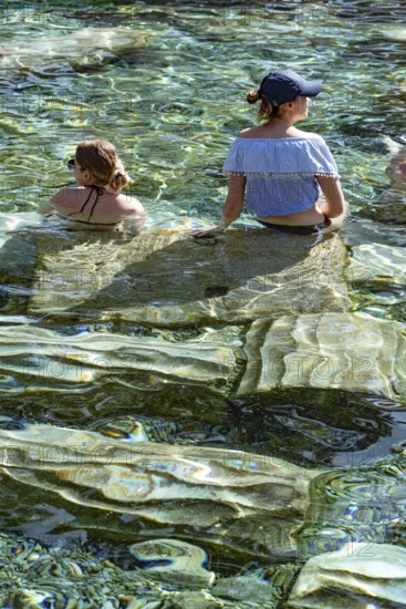 Pamukkale, Turkey, April 25th 2020 Foreign tourists enjoy the healing properties of thermal waters among fallen Roman columns in Cleopatra's Antique Pool in Pamukkale, Turkey Pamukkale, Turkey, April 25th 2020 The Turkish town of Pamukkale sitting at the base of the Travertine Terraces rock formation, a source of natural thermal spring water and world heritage site in western Turkey