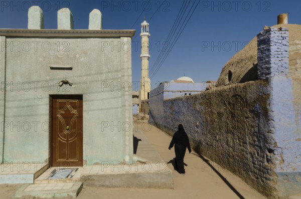Aswan, Egypt. 11th January 2013 A Muslim woman walking towards a mosque in a Nubian Village on the west bank of the River Nile, Aswan, Upper Egypt