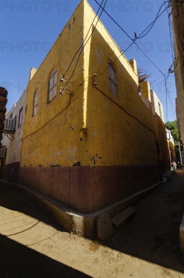 Aswan, Egypt. 8th January 2013 The bright yellow corner of a traditional house, a Nubian Village on Elephantine Island, the River Nile at Aswan in Upper Egypt
