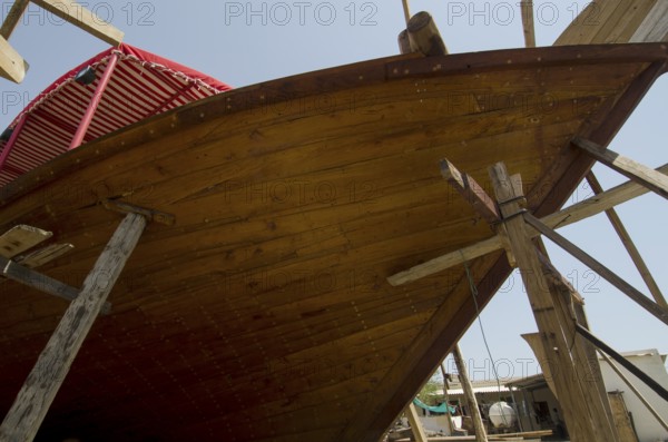 Sur, Oman. May 27th 2014 The wooden hull of a traditional Omani Dhow under construction in a ship yard, Sur, Oman