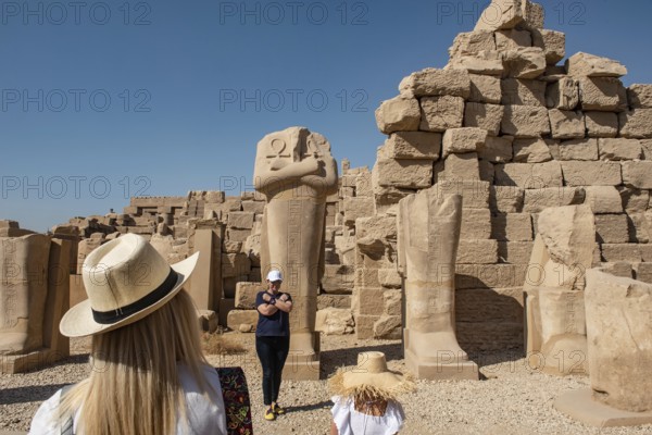 Luxor, Egypt. December 12th 2022 Tourists posing for selfie photographs beside Egyptian statues at Karnak Temple, Luxor, along the River Nile, Egypt