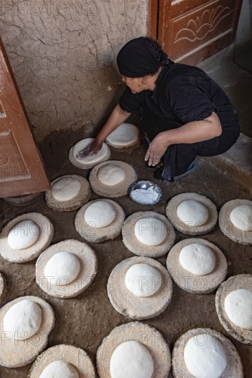 Luxor, Egypt. 13th December 2020 An Egyptian woman preparing dough to make bread in a Nile side village in Upper Egypt