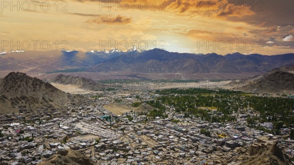 Extensive panoramic view of Leh with snowy mountains in the background under a colorful sky, Leh, Ladakh, Himalayas, India