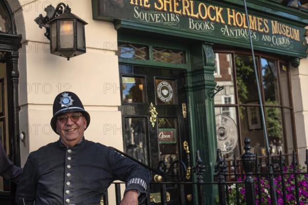 London, England, UK. 9th July 2022. A traditional British policeman poses for photographs outside the Sherlock Homes house and museum, 221b Baker Street, London, Great Britain