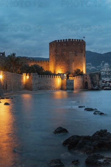 Beautiful evening view of Alanya Harbour and the Red Tower with the Taurus Mountains and Mediterranean Sea, Turkey