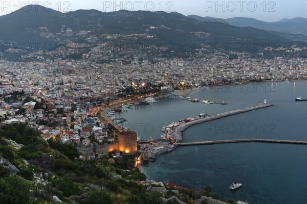 Beautiful evening view of Alanya Harbour and the Red Tower with the Taurus Mountains and Mediterranean Sea, Turkey