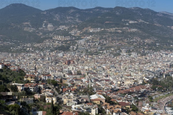 Aerial landscape view of houses and property in Alanya city set on the slopes the Taurus Mountains beside the Mediterranean Sea, Turkey