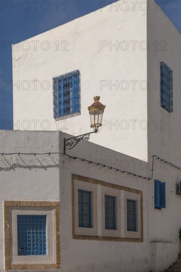 Classic white washed walls and blue painted windows of Tunisian architecture in the UNESCO world heritage site of Tunis Medina, on the Mediterranean coast of North Africa