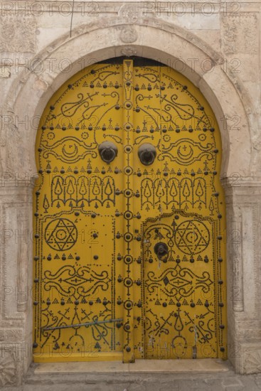 Detailed yellow ornate design of a typical door in the Medina of Tunis, a UNESCO designated quarter of the Tunisian capital, Tunisia